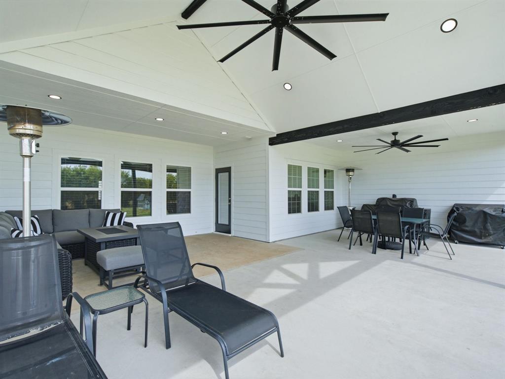 10216 Finch Road Sanger, TX 76266 - Photo 28 of 40 Expansive covered patio with multiple ceiling fans, recessed lighting, and a vaulted ceiling