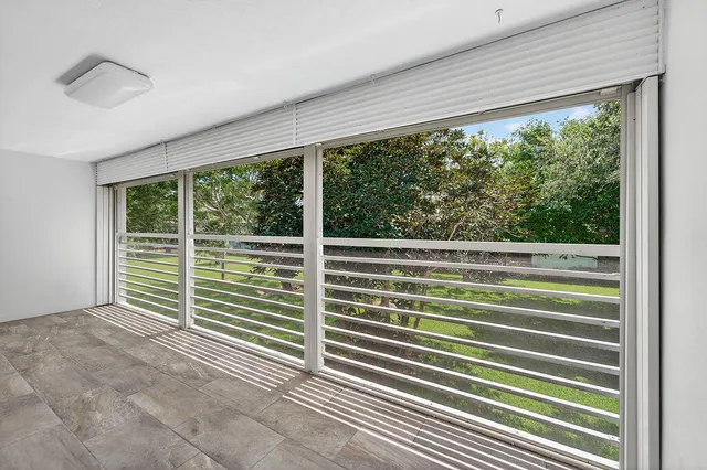 a view of a swimming pool with lawn chairs under an umbrella