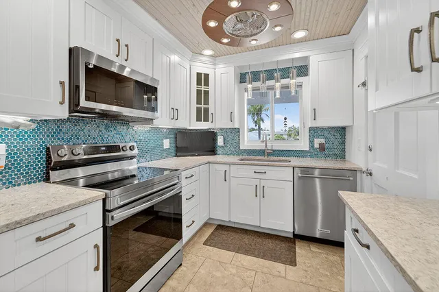 a kitchen with white cabinets and white appliances