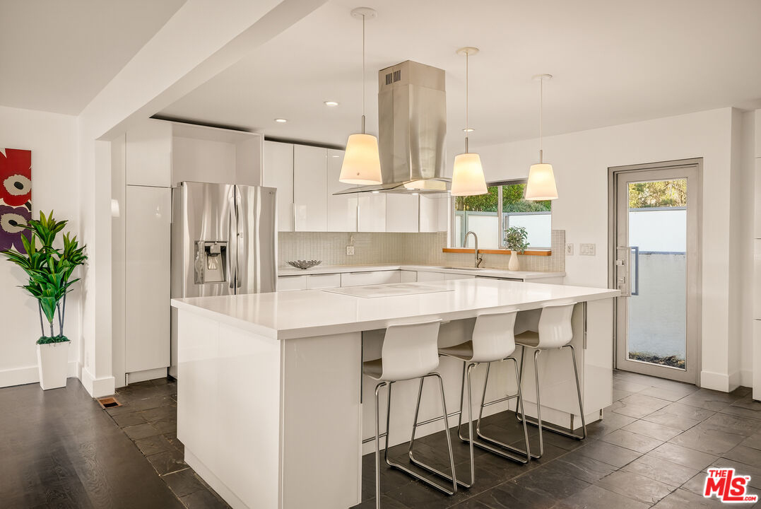 2388 Kimridge Road Beverly Hills, CA 90210 - Photo 11 of 54 a kitchen with stainless steel appliances a refrigerator and a wooden floor