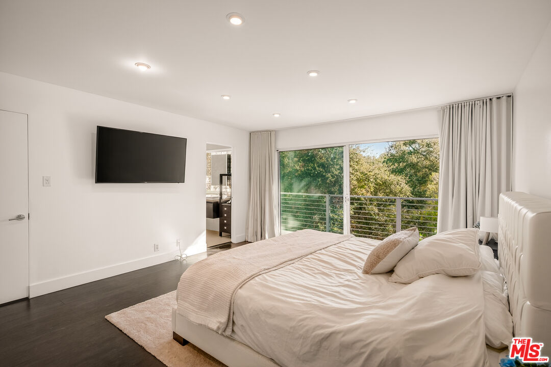 2388 Kimridge Road Beverly Hills, CA 90210 - Photo 22 of 54 a bedroom with a large bed and a flat screen tv