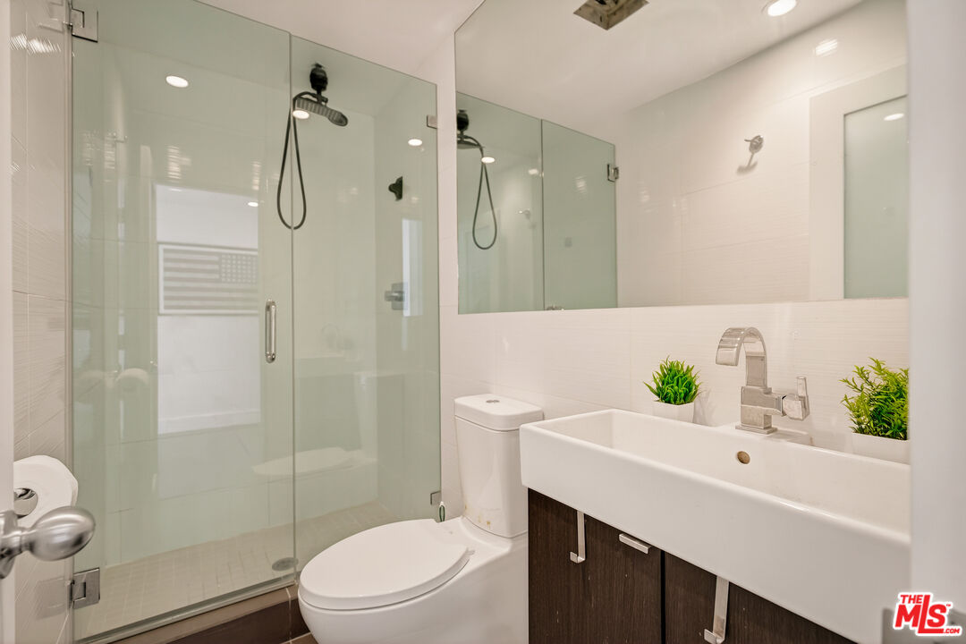 2388 Kimridge Road Beverly Hills, CA 90210 - Photo 30 of 54 a bathroom with a granite countertop sink a toilet and shower