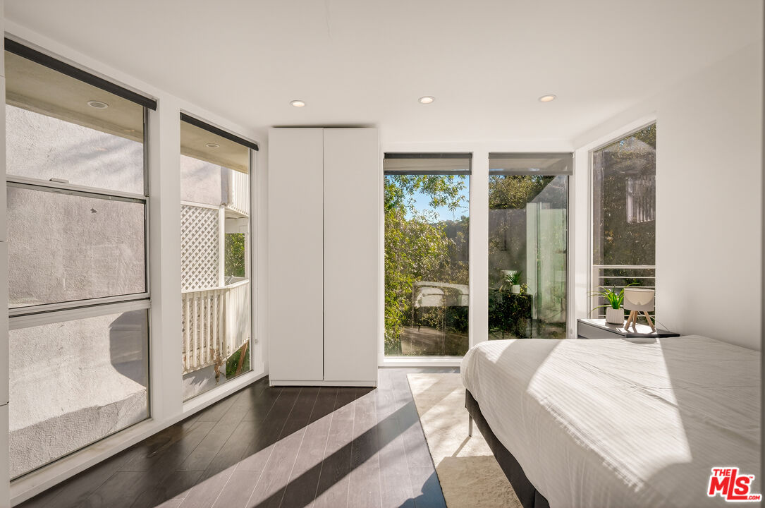 2388 Kimridge Road Beverly Hills, CA 90210 - Photo 31 of 54 a spacious bedroom with a large window and a balcony