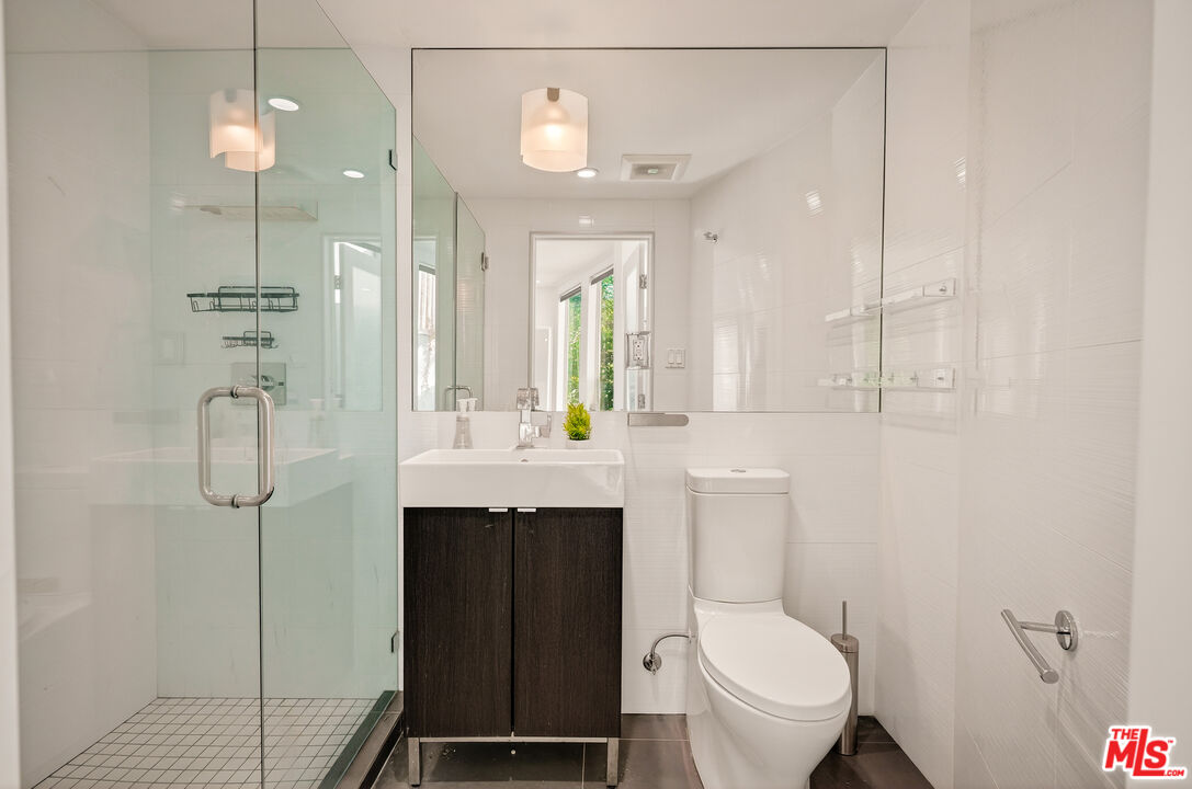 2388 Kimridge Road Beverly Hills, CA 90210 - Photo 37 of 54 a bathroom with a toilet a sink and mirror