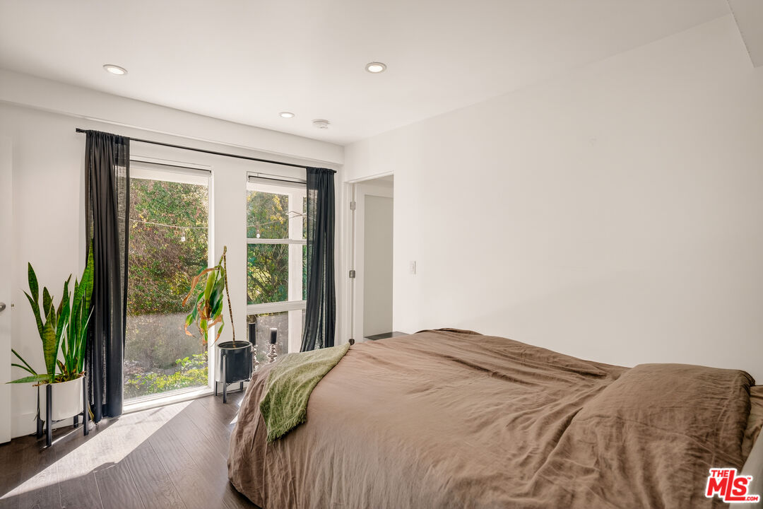 2388 Kimridge Road Beverly Hills, CA 90210 - Photo 42 of 54 a bedroom with a bed and glass window
