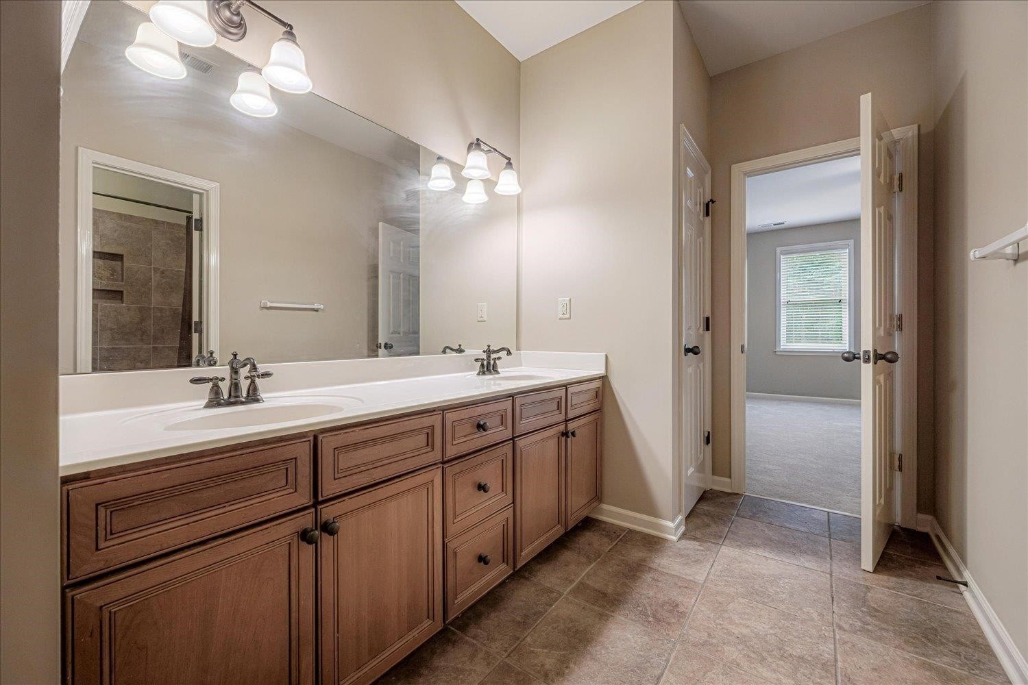 4597 Whisper Spring Drive Collierville, TN 38017 - Photo 28 of 39 a bathroom with a double vanity sink and a mirror
