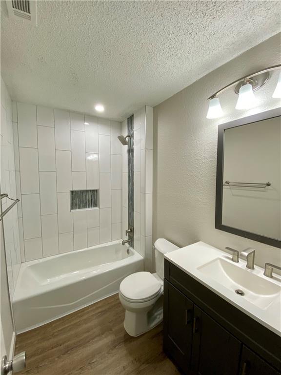 1715 Shadowview Drive, Unit B Austin, TX 78758 - Photo 27 of 28 A well-lit bathroom showcases a pristine tub, shower, and a modern vanity with ample storage.
