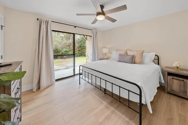a bedroom with a bed a chandelier and next to a window