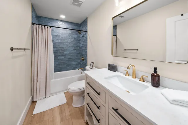 a bathroom with a double vanity sink toilet and shower