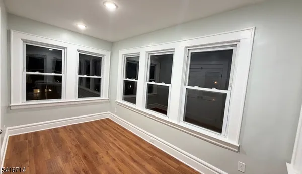 a view of a hallway with wooden floor and windows