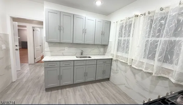 a kitchen with a sink cabinets and wooden floor