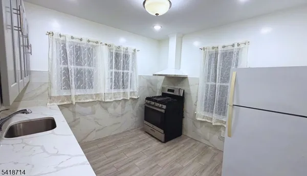 a kitchen with granite countertop a refrigerator and a sink