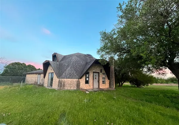 a front view of house with a garden