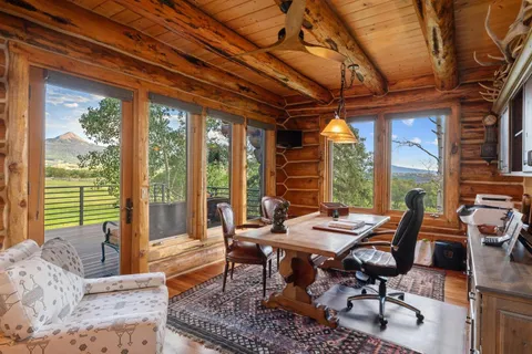 a dining room with furniture a rug and a large window