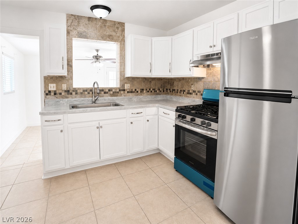 2870 South Sandhill Road Las Vegas, NV 89121 - Photo 29 of 64 A well-equipped culinary space offers white cabinetry, tile flooring, and essential stainless steel appliances.