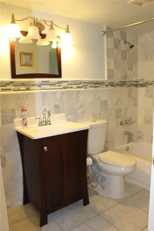 a bathroom with a sink vanity mirror and toilet