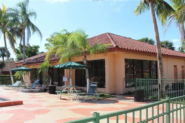 a patio with a table and chairs and potted plants
