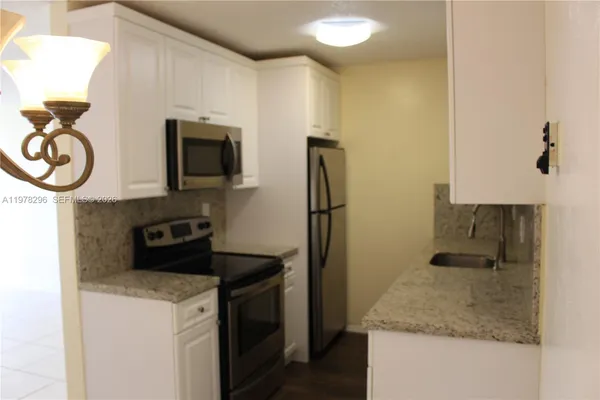 a kitchen with stainless steel appliances granite countertop a sink and a refrigerator