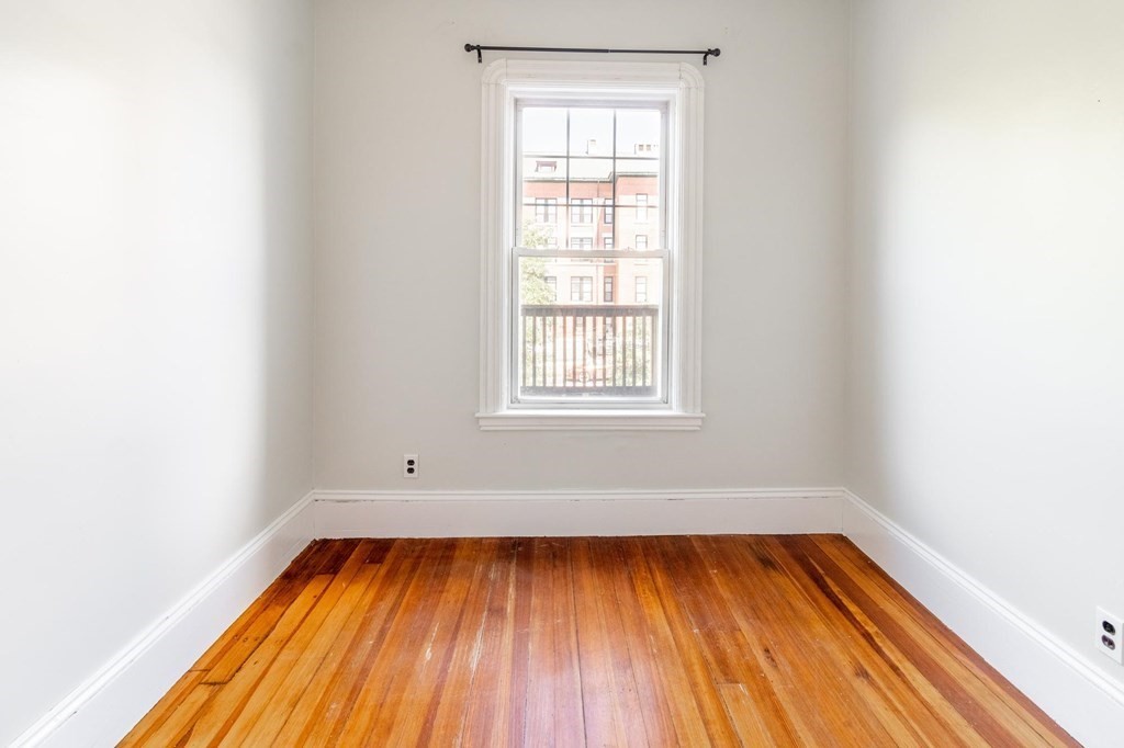 789 Columbia Road, Unit 2 Boston, MA 02125 - Photo 10 of 19 an empty room with wooden floor and windows