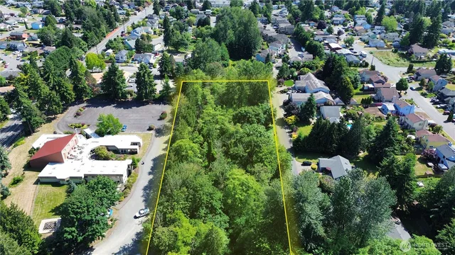 an aerial view of residential house with outdoor space and trees all around