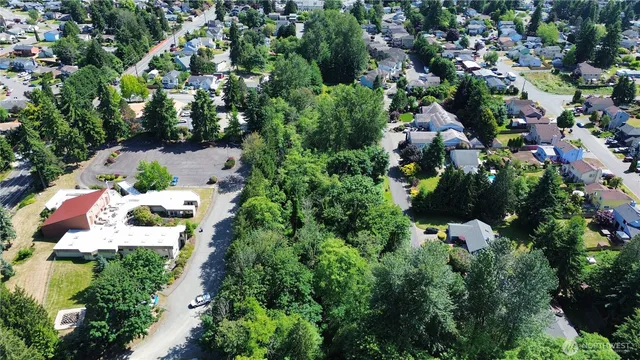 an aerial view of residential house with outdoor space and trees all around