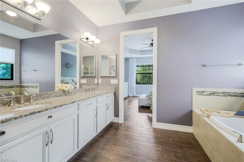 14374 Tuscany Pointe Trail Naples, FL 34120 - Photo 13 of 22 a spacious bathroom with a granite countertop sink and a mirror