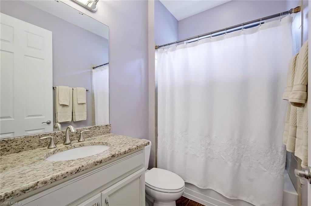 14374 Tuscany Pointe Trail Naples, FL 34120 - Photo 15 of 22 a bathroom with a granite countertop sink toilet and a mirror