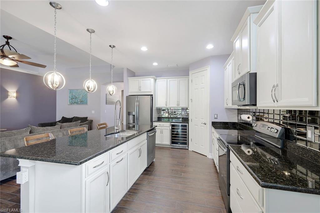 14374 Tuscany Pointe Trail Naples, FL 34120 - Photo 8 of 22 a large kitchen with stainless steel appliances granite countertop a sink stove and refrigerator
