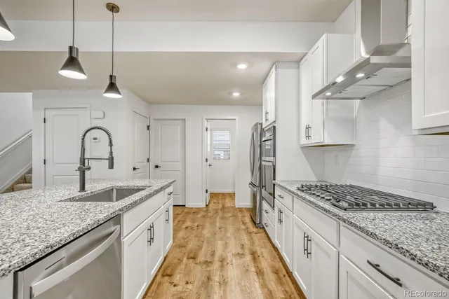 a kitchen with stainless steel appliances a refrigerator and a stove top oven