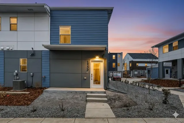 a view of a house with a barbeque and wooden stairs