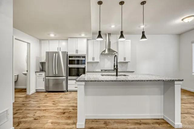 a kitchen with stainless steel appliances granite countertop a stove a sink and a refrigerator