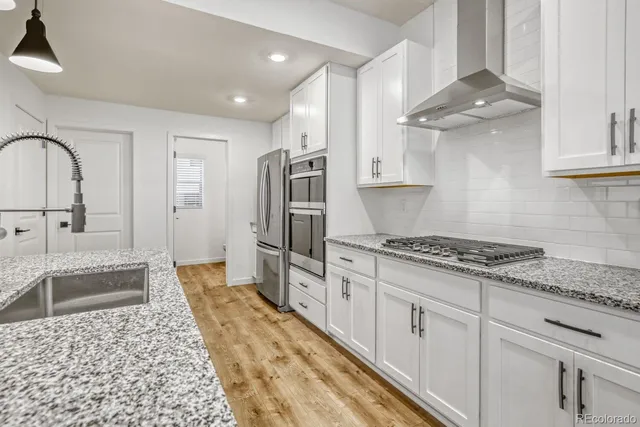 a kitchen with stainless steel appliances a refrigerator sink and cabinets