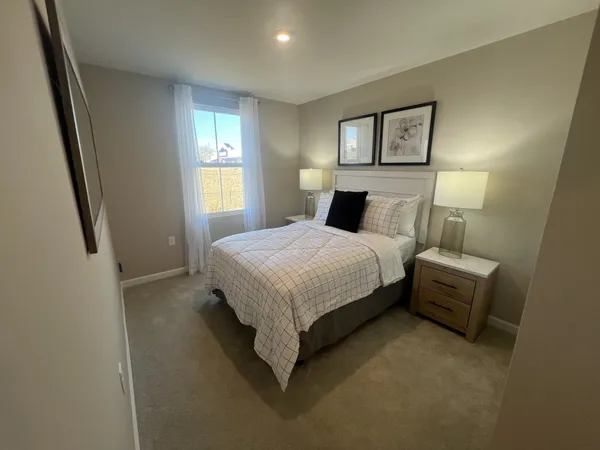 a bedroom with a bed lamp and a window