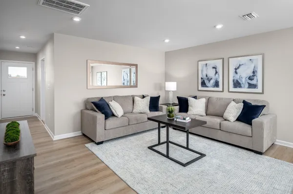 a living room with furniture a rug and a wooden floor