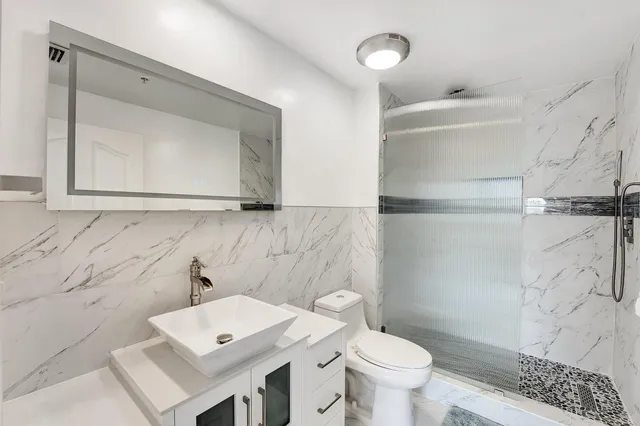 a bathroom with a sink a toilet and mirror