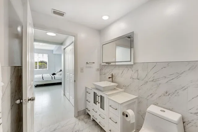 a bathroom with a double vanity sink mirror and toilet