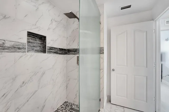 a kitchen with stainless steel appliances kitchen island granite countertop a refrigerator and a chair