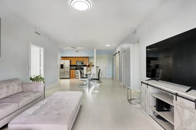 a living room with furniture a wooden floor and a large window