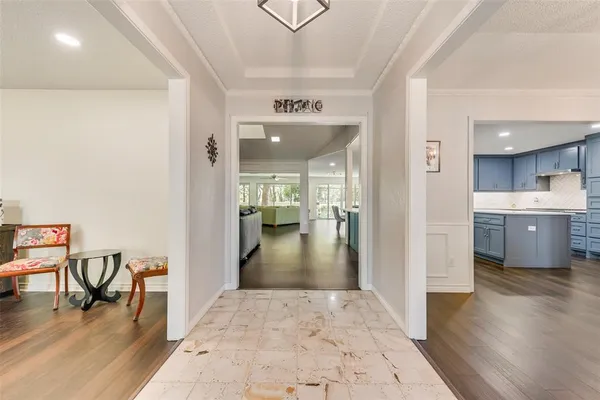 a view of a hallway to a livingroom with furniture and an entryway