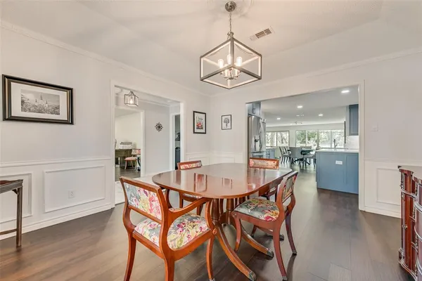 a view of a dining room and livingroom with furniture wooden floor a chandelier