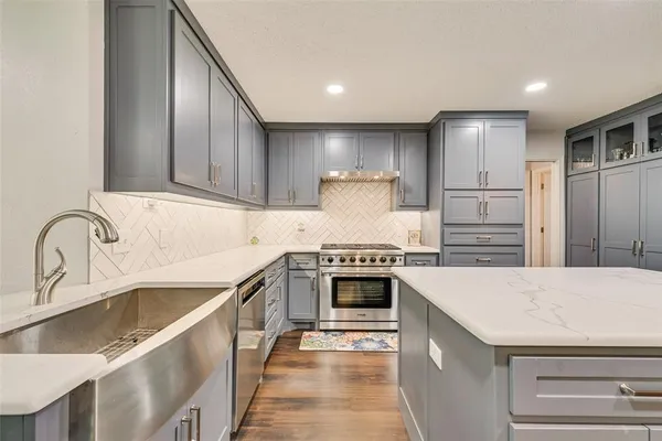 a kitchen with kitchen island granite countertop a sink stove and refrigerator