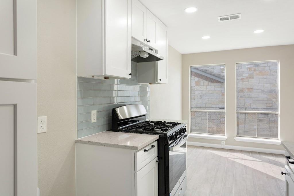 9604 Crown Ridge Road Austin, TX 78753 - Photo 9 of 24 Bright white cabinetry and a sleek gas range highlight this contemporary culinary space.