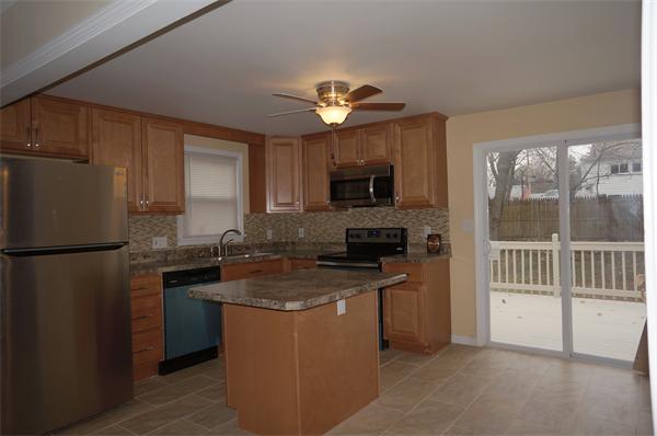 120 Navajo Road Springfield, MA 01109 - Photo 3 of 16 a kitchen with a refrigerator a stove a sink a microwave and cabinets