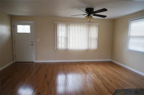 120 Navajo Road Springfield, MA 01109 - Photo 4 of 16 an empty room with wooden floor chandelier fan and windows