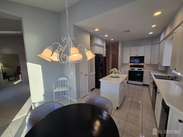 a kitchen with a sink a stove and chairs