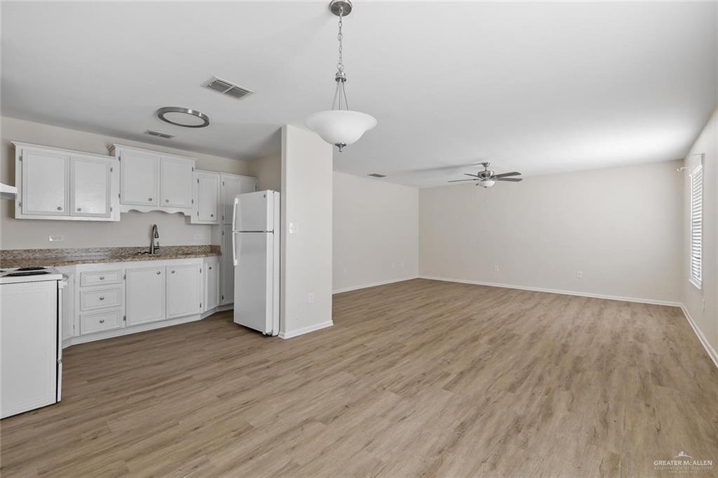 1105 West Stubbs Street, Unit 4 Edinburg, TX 78539 - Photo 12 of 12 a kitchen with a refrigerator a sink and cabinets