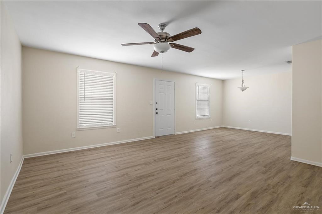 1105 West Stubbs Street, Unit 4 Edinburg, TX 78539 - Photo 8 of 12 an empty room with wooden floor fan and windows
