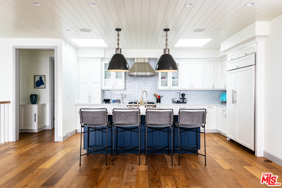 703 Bayview Drive Manhattan Beach, CA 90266 - Photo 9 of 24 a kitchen with stainless steel appliances a table chairs and a refrigerator