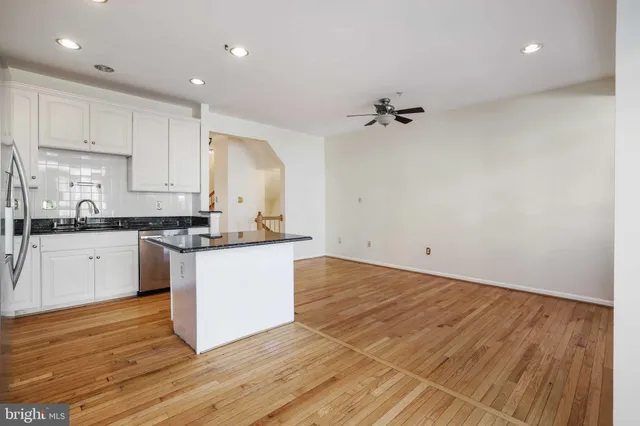 a kitchen with granite countertop a sink cabinets and wooden floor