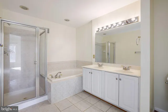 a bathroom with a tub a sink and mirror